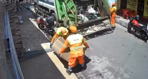 Mulher deixa sofá secando na calçada, e equipe de limpeza leva em caminhão do lixo